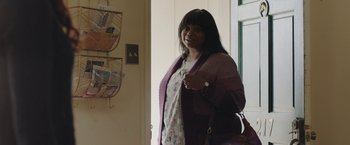 Movie still from “Ma” (2019), directed by Tate Taylor – A woman standing in front of a window holding a purse; Medium shot, Over the shoulder angle