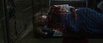 Movie still from “Ma” (2019), directed by Tate Taylor – A woman laying in a cage with blood on her face; Medium shot, Overhead angle