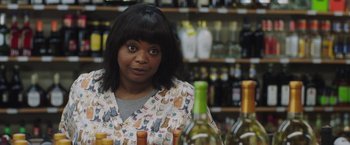 Movie still from “Ma” (2019), directed by Tate Taylor – A woman sitting in front of a table of wine bottles; Close Up shot, Over the shoulder angle