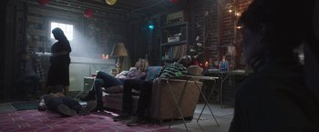 Movie still from “Ma” (2019), directed by Tate Taylor – Two people are sitting on a couch in a living room; Wide shot, Low angle