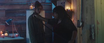Movie still from “Ma” (2019), directed by Tate Taylor – A woman holding onto a woman's tie while standing next to a woman; Medium shot, Over the shoulder angle