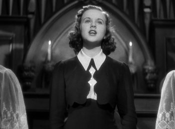 Movie still from “Mad About Music” (1938), directed by Norman Taurog – A woman in a black dress and a white tie; Medium shot, Low angle