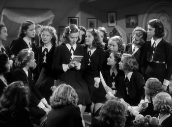 Movie still from “Mad About Music” (1938), directed by Norman Taurog – A group of young women sitting around each other; Medium shot, High angle