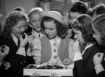 Movie still from “Mad About Music” (1938), directed by Norman Taurog – A group of young women gathered around a cake; Medium shot, High angle