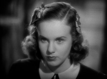 Movie still from “Mad About Music” (1938), directed by Norman Taurog – A woman with a bow in her hair looking at the camera; Close Up shot, High angle