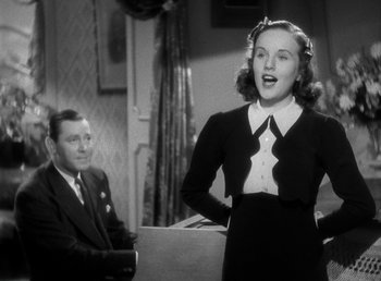 Movie still from “Mad About Music” (1938), directed by Norman Taurog – An old photo of a man and a woman singing; Medium shot, Low angle