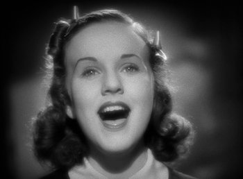 Movie still from “Mad About Music” (1938), directed by Norman Taurog – An old photo of a young woman with a surprised look on her face; Close Up shot, Low angle