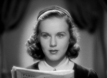 Movie still from “Mad About Music” (1938), directed by Norman Taurog – A black - and - white photo of a woman reading a newspaper; Close Up shot, High angle