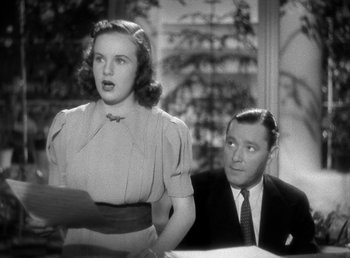 Movie still from “Mad About Music” (1938), directed by Norman Taurog – An old photo of a man and a woman sitting at a table; Close Up shot, Low angle