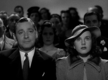 Movie still from “Mad About Music” (1938), directed by Norman Taurog – A black and white photo of a man and woman in front of a group of people; Close Up shot, High angle