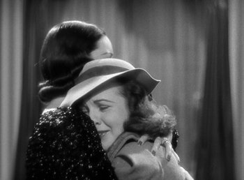 Movie still from “Mad About Music” (1938), directed by Norman Taurog – Two women are hugging each other in a black and white photo; Medium shot, Over the shoulder angle