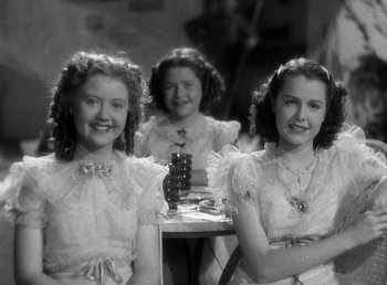 Movie still from “Mad About Music” (1938), directed by Norman Taurog – Three young girls sitting at a table with a guitar; Medium shot, Low angle
