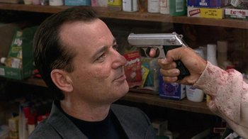 Movie still from “Mad Dog and Glory” (1993), directed by John McNaughton – A man is holding a gun up to his face; Close Up shot, Over the shoulder angle