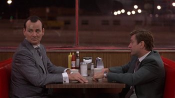 Movie still from “Mad Dog and Glory” (1993), directed by John McNaughton – Two men sitting at a table in a restaurant; Medium shot, Over the shoulder angle