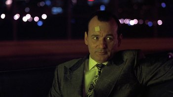 Movie still from “Mad Dog and Glory” (1993), directed by John McNaughton – A man in a business suit with a bandage on his forehead; Close Up shot, Low angle