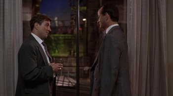 Movie still from “Mad Dog and Glory” (1993), directed by John McNaughton – Two men in business suits are talking outside; Medium shot, Over the shoulder angle