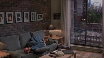 Movie still from “Mad Dog and Glory” (1993), directed by John McNaughton – A girl laying on a couch in a living room; Wide shot, High angle