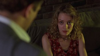 Movie still from “Mad Dog and Glory” (1993), directed by John McNaughton – A woman sitting in front of a man on a couch; Close Up shot, Over the shoulder angle