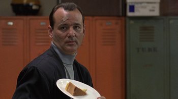 Movie still from “Mad Dog and Glory” (1993), directed by John McNaughton – A man holding a piece of cake in front of him; Close Up shot, Over the shoulder angle