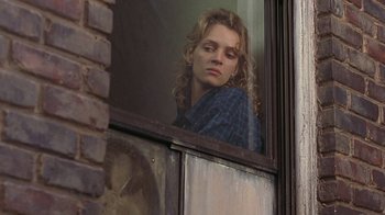 Movie still from “Mad Dog and Glory” (1993), directed by John McNaughton – A woman looking out of a window at a brick building; Close Up shot, Low angle