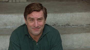 Movie still from “Mad Dog and Glory” (1993), directed by John McNaughton – A person sitting on some steps; Close Up shot, Low angle