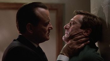 Movie still from “Mad Dog and Glory” (1993), directed by John McNaughton – Two men in suits are looking at each other; Close Up shot, Low angle