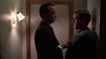 Movie still from “Mad Dog and Glory” (1993), directed by John McNaughton – Two men in a room talking to each other; Medium shot, Over the shoulder angle