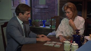 Movie still from “Mad Dog and Glory” (1993), directed by John McNaughton – A man and a woman sitting at a wooden table; Medium shot, Over the shoulder angle