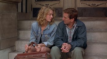 Movie still from “Mad Dog and Glory” (1993), directed by John McNaughton – A man and a woman sitting next to each other on steps; Medium shot, Low angle