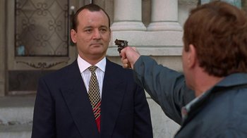 Movie still from “Mad Dog and Glory” (1993), directed by John McNaughton – A man in a suit and tie holding a gun; Close Up shot, Over the shoulder angle