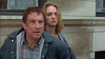 Movie still from “Mad Dog and Glory” (1993), directed by John McNaughton – A man and a woman standing next to each other in front of a building; Close Up shot, Low angle