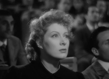Movie still from “Madame Curie” (1943), directed by Mervyn LeRoy – An old black and white photo of a woman in a crowd; Close Up shot, High angle