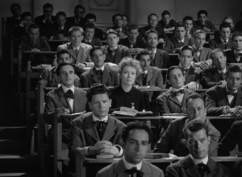 Movie still from “Madame Curie” (1943), directed by Mervyn LeRoy – A group of men and women sitting in a classroom; Wide shot, High angle