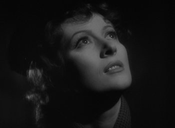 Movie still from “Madame Curie” (1943), directed by Mervyn LeRoy – An old black and white photo of a woman looking up; Close Up shot, Low angle
