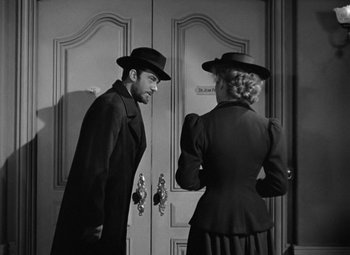Movie still from “Madame Curie” (1943), directed by Mervyn LeRoy – A black and white photo of a man and a woman; Medium shot, Over the shoulder angle