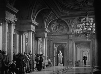 Movie still from “Madame Curie” (1943), directed by Mervyn LeRoy – A group of people standing in a large room; Extreme Wide shot, Low angle