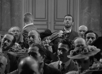 Movie still from “Madame Curie” (1943), directed by Mervyn LeRoy – Black and white photograph of a crowd of people; Medium shot, Over the shoulder angle