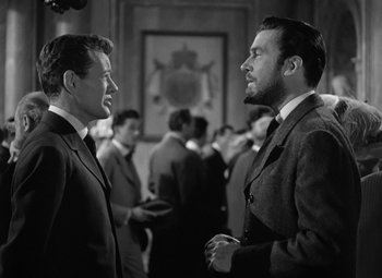 Movie still from “Madame Curie” (1943), directed by Mervyn LeRoy – A black and white photo of two men in suits talking; Medium shot, Over the shoulder angle