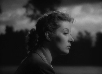 Movie still from “Madame Curie” (1943), directed by Mervyn LeRoy – A black - and - white photo of a woman in a field; Close Up shot, Low angle
