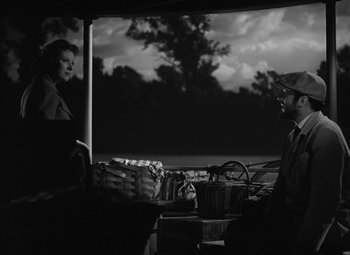 Movie still from “Madame Curie” (1943), directed by Mervyn LeRoy – A man and a woman are standing in front of a basket; Medium shot, Over the shoulder angle