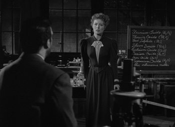 Movie still from “Madame Curie” (1943), directed by Mervyn LeRoy – An old photo of a woman and a man in a restaurant; Medium shot, Over the shoulder angle
