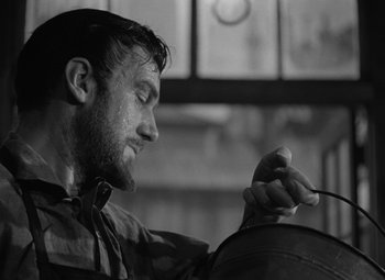 Movie still from “Madame Curie” (1943), directed by Mervyn LeRoy – Black and white photograph of a man working on something; Close Up shot, Low angle
