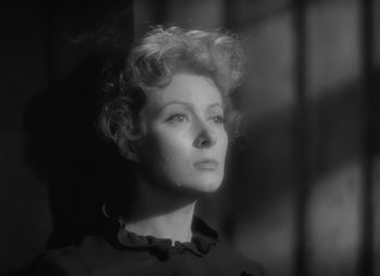 Movie still from “Madame Curie” (1943), directed by Mervyn LeRoy – A black - and - white photo of a woman looking into the distance; Close Up shot, Low angle