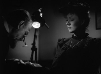 Movie still from “Madame Curie” (1943), directed by Mervyn LeRoy – A man and a woman are looking at each other in a dimly - lit room; Close Up shot, Low angle