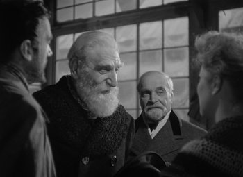 Movie still from “Madame Curie” (1943), directed by Mervyn LeRoy – A group of men standing next to each other; Medium shot, Over the shoulder angle