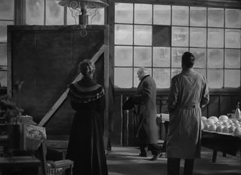 Movie still from “Madame Curie” (1943), directed by Mervyn LeRoy – A group of people standing in front of a window; Wide shot, Low angle