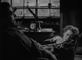 Movie still from “Madame Curie” (1943), directed by Mervyn LeRoy – A man and a woman sitting on a couch in front of a window; Medium shot, High angle