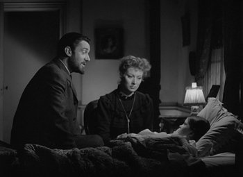 Movie still from “Madame Curie” (1943), directed by Mervyn LeRoy – A man and a woman sitting next to each other in a bed; Medium shot, High angle