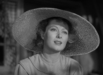 Movie still from “Madame Curie” (1943), directed by Mervyn LeRoy – An old photo of a woman wearing a large hat; Close Up shot, Low angle