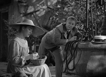 Movie still from “Madame Curie” (1943), directed by Mervyn LeRoy – An old photo of a man and a woman; Medium shot, High angle